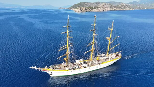 Aerial drone cinematic video of beautiful 3 mast barque or barc type classic sailing wooden boat cruising in Mediterranean deep blue sea