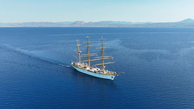 Aerial drone cinematic video of beautiful 3 mast barque or barc type classic sailing wooden boat cruising in Mediterranean deep blue sea