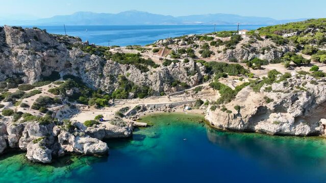 Aerial drone video of iconic archaeological site of Heraion built by the sea forming a small secluded beach,near lake Vouliagmeni, Loutraki, Perachora, Greece