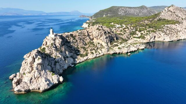 Aerial drone video of beautiful and picturesque cape Melagavi forming a small peninsula with unique lighthouse stand out next to archaeological site of Heraion, Loutraki, Greece