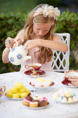 Girl, child and pouring tea in garden with party for birthday, celebration and playing outdoor in home. Person, kid and porcelain cup in backyard of house with dress up, beverage and role play fun