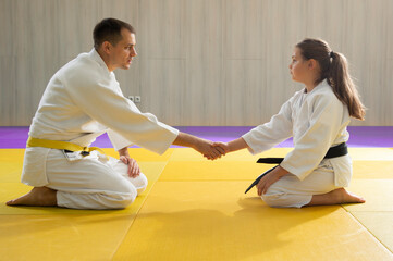 Young yellow belt judo man and young black belt judo girl