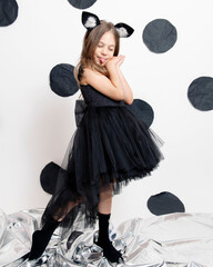 little girl in a black dress on a white background