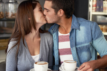 Love, kiss and couple drinking coffee in cafe, care and bonding together on valentines day date....