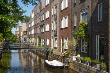 Fototapeta na wymiar Modern houses with narrow metal bridges over the canal in the new Vathorst district in Amersfoort.
