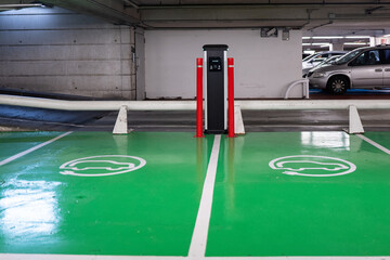 Close-up view of electric charging stations with vibrant green ground markings in an indoor parking lot