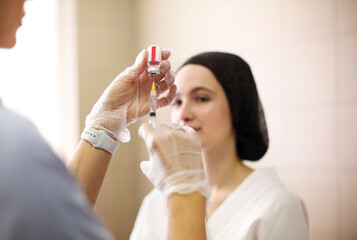 Cosmetologist making injection during beauty procedure in salon