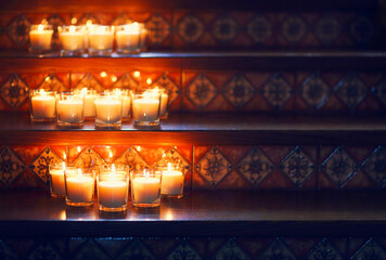 Burning small candles in glasses, romantic decoration in vintage style, selective focus.