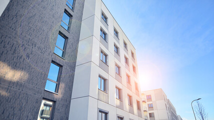 Modern apartment building in sunny day. Exterior, residential house facade. Residential area with modern, new and stylish living block of flats.  - obrazy, fototapety, plakaty
