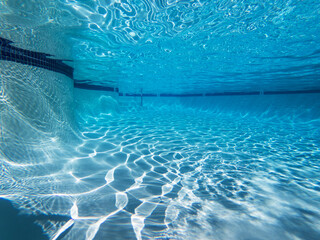 Underwater light patterns in large clean swimming pool.