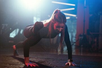 Athletic Woman's Flexible Push-Up in Gym
