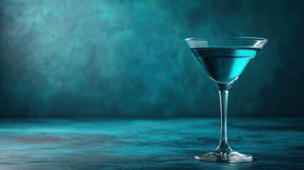  a close up of a martini glass with a blue liquid in it on a blue table with a green wall in the background.