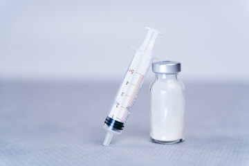 Close up of syringe resting on glass bottle of antibiotic creating space and simplicity