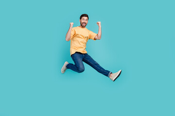 Fototapeta na wymiar Full length photo of sportive ambitious sports man jumping raised fists up leader in competition isolated on aquamarine color background