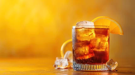 Fotobehang  a glass of ice tea with a slice of orange on the rim and a lemon wedge on the edge of the glass. © Shanti