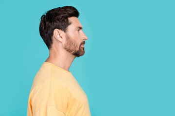 Side photo of confident handsome boyfriend in yellow basic t shirt looking novelty his unshaven...