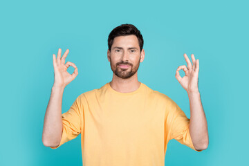Portrait photo of brunet hair handsome man wearing yellow t shirt demonstrate alright symbol double...