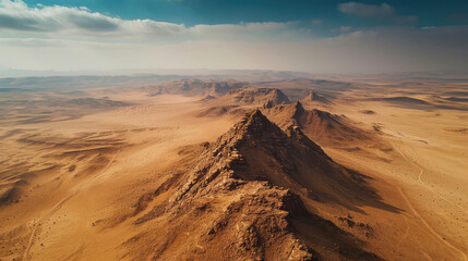 Fototapeta na wymiar Aerial view of a majestic mountain rising from the vast expanse of a desert landscape
