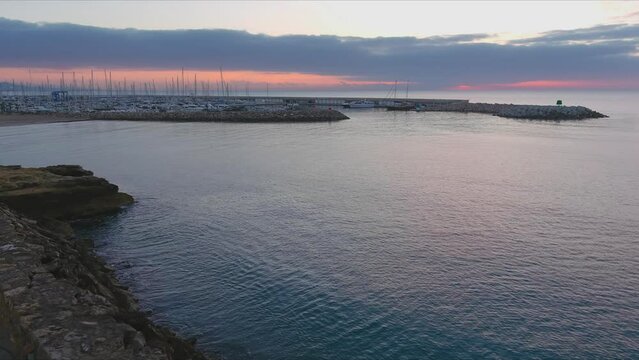 Drone flying Roc de Sant Gaieta coast with view of Roda de Bara sports port