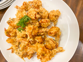 A pile of crispy crunchy fried shrimp served on a white porcelain plate. Concept for whole healthy food, omega-3, animal protein. 