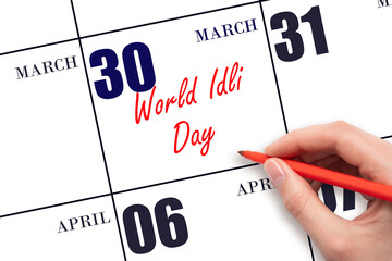 March 30. Hand writing text World Idli Day on calendar date. Save the date.