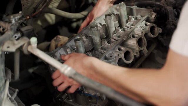 Auto mechanic installs piston using ring compressor into engine block in garage shop guide technician rebuild car maintenance replace engine parts DIY overhaul automotive repair closeup hands at work