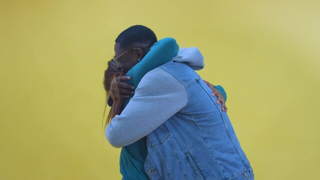 Happy black couple hug isolated on yellow background. High quality photo