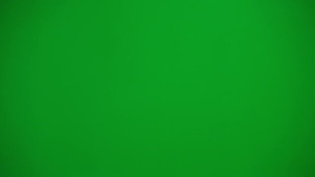 Little girl in white dress on chroma key green screen isolated background jumping up and down holding hands up looking at camera smiling.
