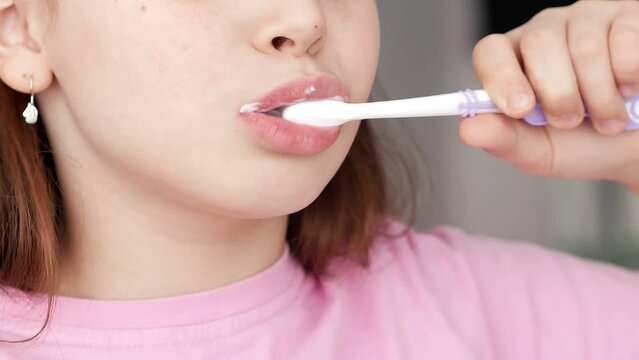 Mouth of a little girl in close-up brushing her teeth with toothpaste at home, oral hygiene. The concept of the morning.