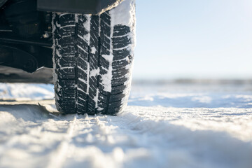 Car tires on snow covered road in winter