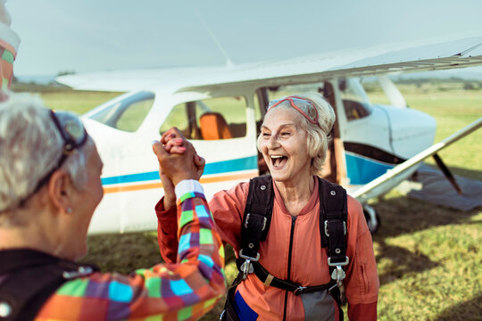 Two excited senior women getting ready to skydive