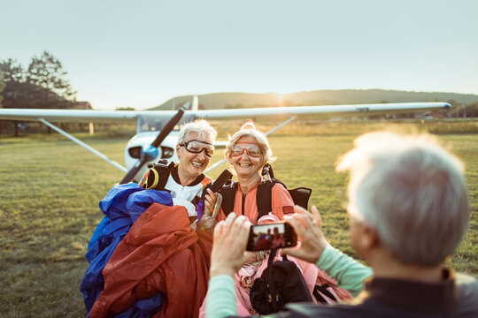 Happy senior women posing for picture after skydiving