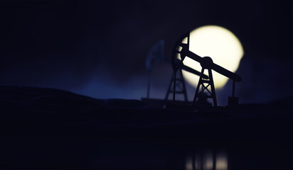 In the evening, the silhouette of oilfield derrick. Beam pumping unit under the night, closeup of...
