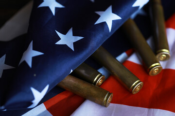 Many bullets cartridges and medals on United States flag. Concept of war glory victory. Gun...