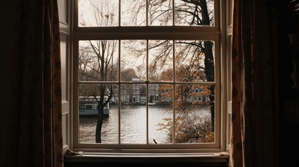 a window with a view of a body of water and a house on the other side of the window sill.