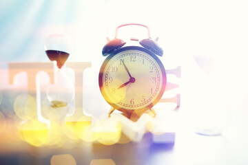 Background with a clock on the table and bokeh in pastel rainbow colors. Time for rest and travel.