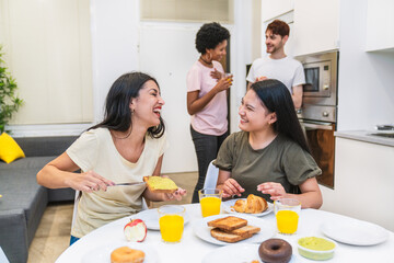 Laughter fills the room as friends engage in joyful conversation around a breakfast table with various foods.