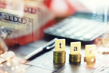 Tax wooden letter on wooden block.Pay tax .Income tax return. Double exposure city, dollar.