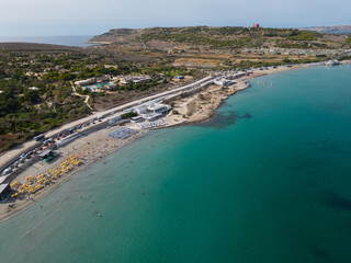 Fototapeta premium Aerial view of beautiful Ghadira Bay, Mellieha, Malta with turquoise sea and sandy beach. Coastal road towards Red tower and Gozo ferry terminal. 