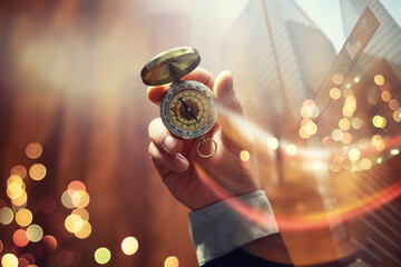Double exposure businessman with vintage compass in a hand and skyscraper.  concept to make decision or choose direction - obrazy, fototapety, plakaty