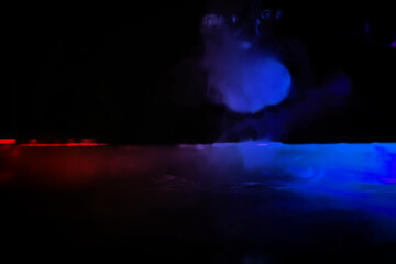 colorful smoke on dark background. Color steam on a black background. Red and blue smoke. Copy space.