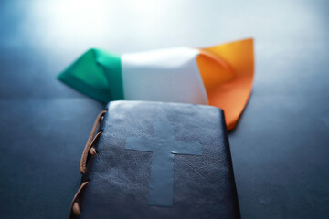 A leather-bound Bible on the table. Religious Christian Irish celebration. Four-leaf clover symbol...