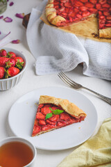 Slice Of Delicious Fresh Baked Vegan Strawberry Galette With Mint Leaves On White Ceramic Plate