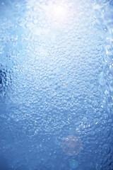 Bubbles and seething water in the light of sunlight.Blue water texture.