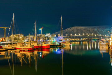 View of a marina and harbor in Tromso at night, North Norway. Tromso is considered the northernmost city in the world with a population above 50,000