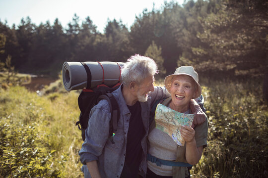 Senior couple hiking in nature with a map