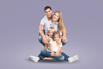 young joyful parents with children posing on background