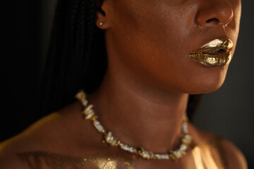 Portrait of an African American woman with a gold necklace around her neck. There are streaks of...