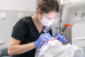 The dentist examines the patient's mouth and teeth using a dental explorer. Periodic preventive...