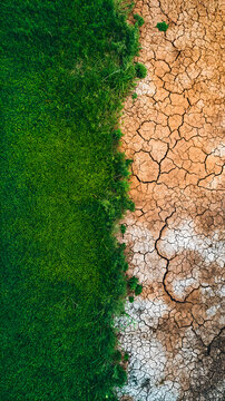 Imagen a&eacute;rea de un terreno f&eacute;rtil con prados verdes y otra zona de tierra seca y quemada como s&iacute;mbolo del cambio climatico